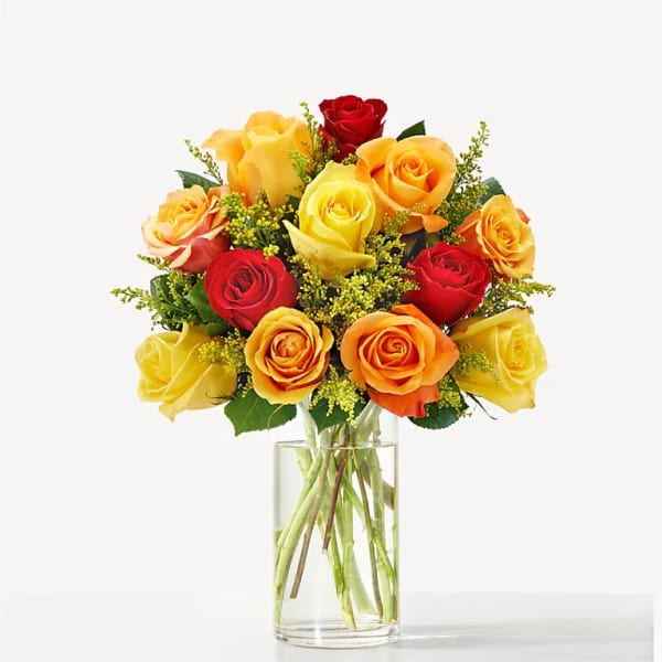 Bouquet of red, yellow, and orange roses in a clear glass vase