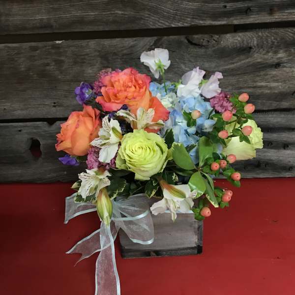 Colorful mixed bouquet in a rustic wooden box with a sheer ribbon