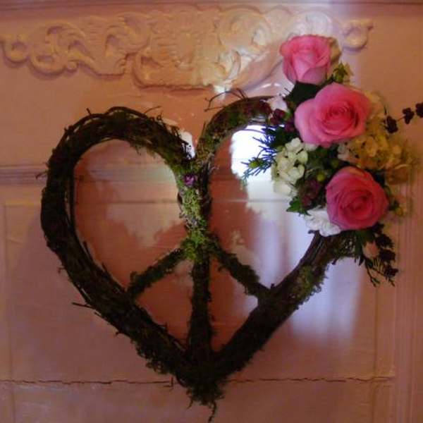 Heart-shaped floral wreath with pink roses on a door