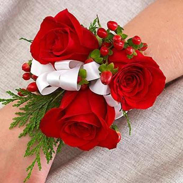 Red rose wrist corsage with white ribbon and berries