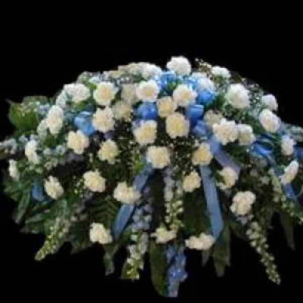 White and blue floral funeral spray with cascading ribbons