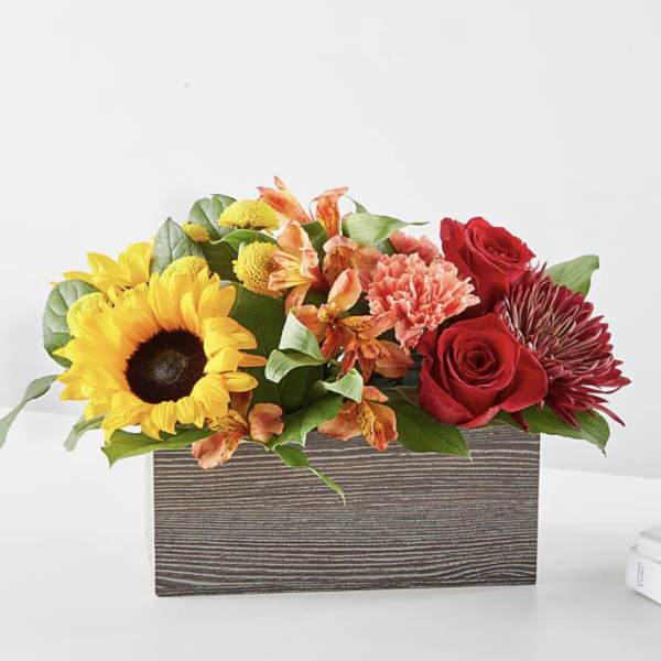 Mixed bouquet in a rectangular wood-look box with sunflowers and red roses