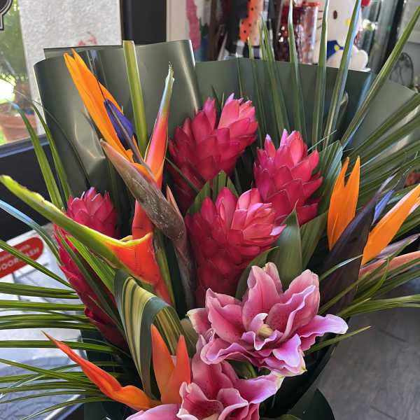 Tropical bouquet with pink orchids and orange bird-of-paradise flowers