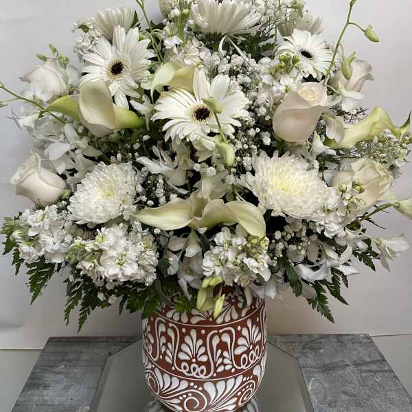 White floral arrangement in a decorative terracotta vase