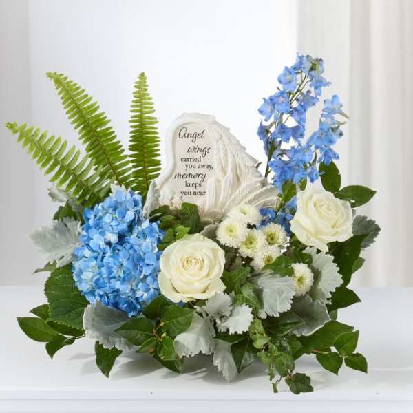 Blue and white floral sympathy arrangement with a memorial stone