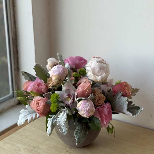 Pink and white floral arrangement in a round vase