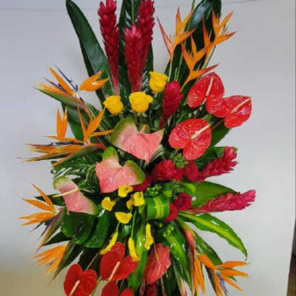 Tall tropical floral standing arrangement with red, orange, and pink blooms