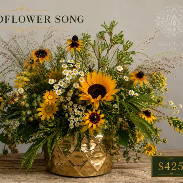 Sunflower and daisy arrangement in a gold vase