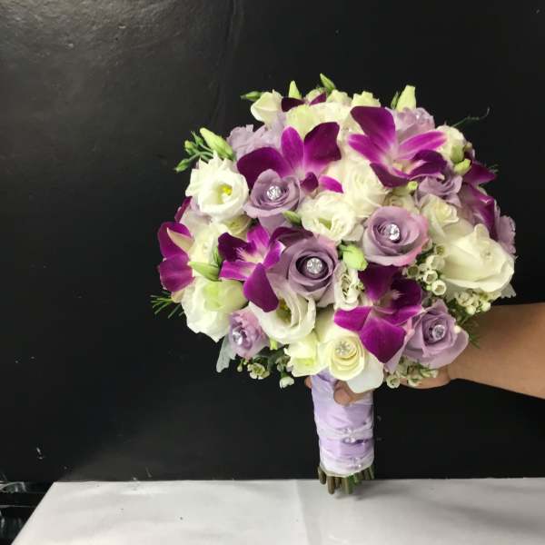 Purple and white bridal bouquet with roses and orchids