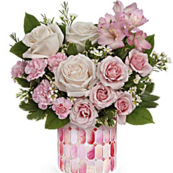 Pink and white roses in a patterned glass vase