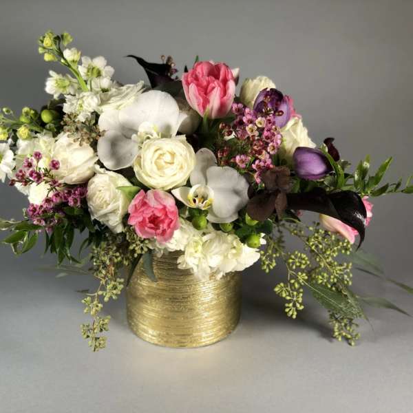 Mixed bouquet in a gold vase with pink, white, and purple flowers