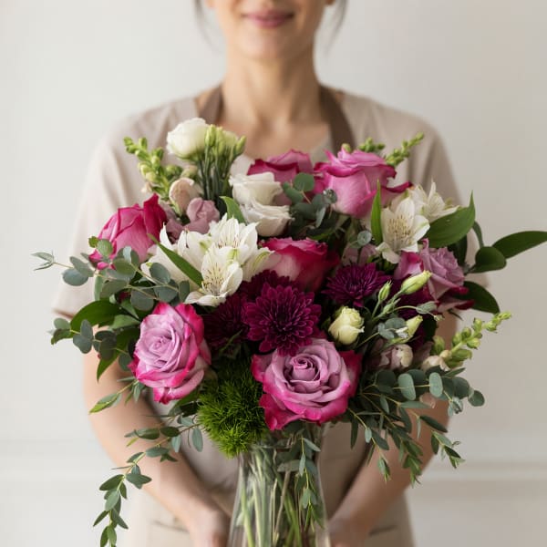 Bouquet of pink and white roses with white alstroemeria in a glass vase