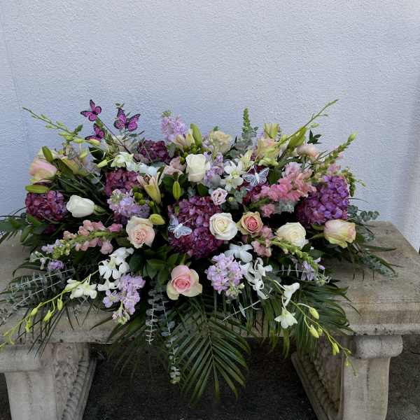 Large floral arrangement with pink and white roses, lilies, and purple blooms