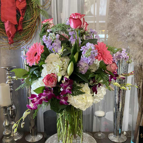 Mixed bouquet of pink, white, and purple flowers in a glass vase