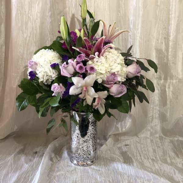 Mixed pink and white floral arrangement in a silver vase