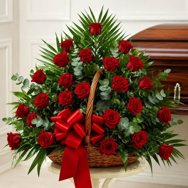 Basket arrangement of red roses with a large red bow