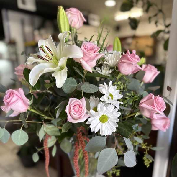 Pink roses and white lilies in a glass vase