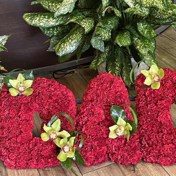 Large red floral letters decorated with yellow orchids