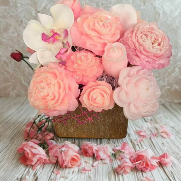 Pink floral arrangement with roses and an orchid in a square vase