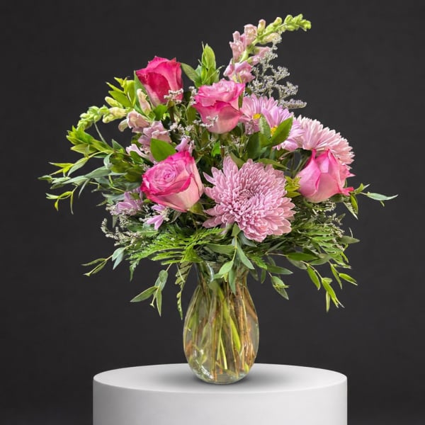 Pink roses and lavender chrysanthemums in a clear glass vase