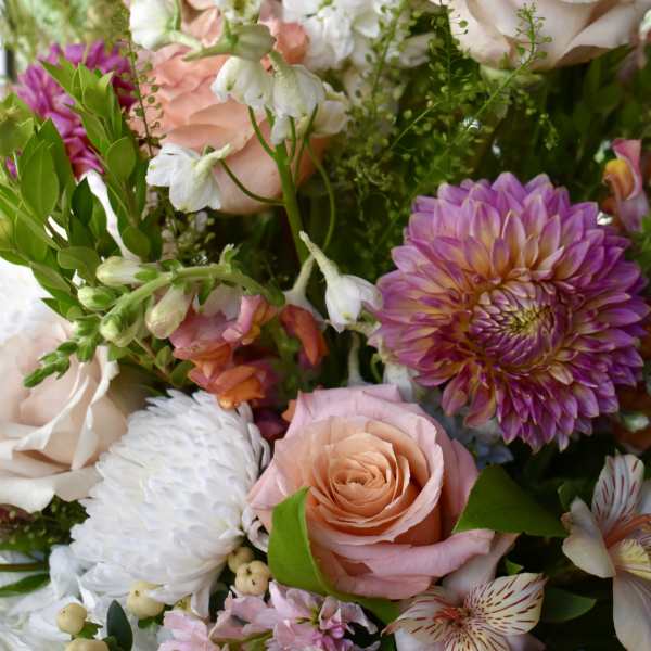 Mixed bouquet with pink roses, white blooms, and purple dahlias