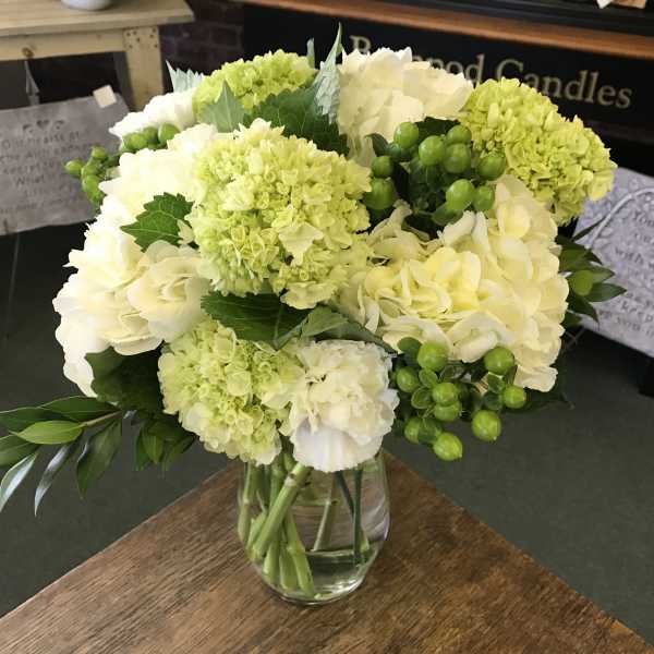 White and pale green bouquet in a clear glass vase
