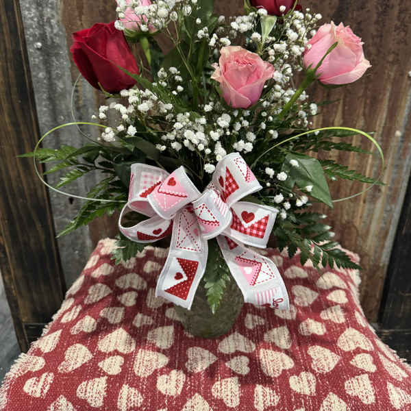 Bouquet of pink and red roses with baby's breath and a heart ribbon
