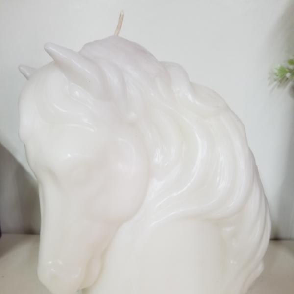 White unicorn-shaped candle with a molded mane and horn