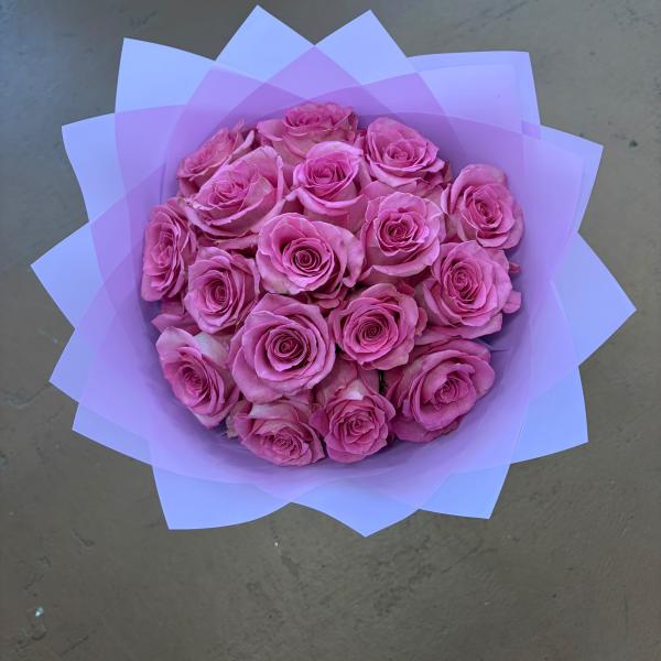 Bouquet of pink roses wrapped in lavender paper