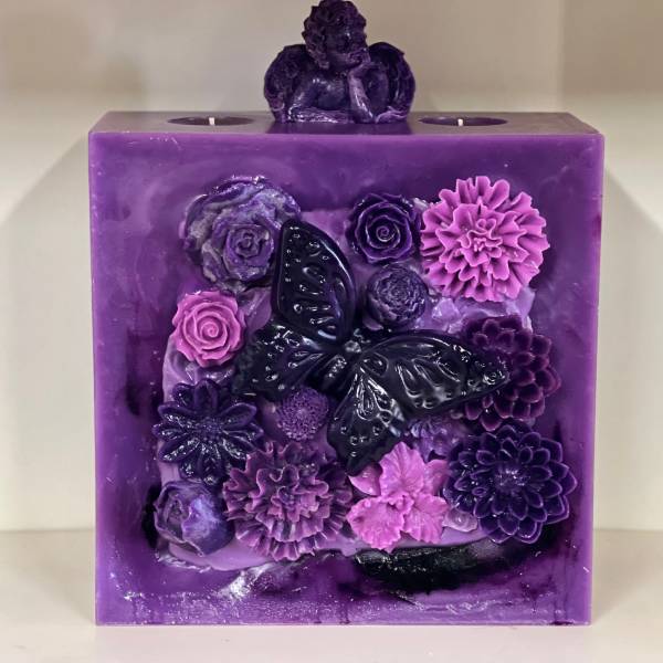 Purple decorative candle with butterfly and flower reliefs