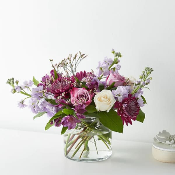 Mixed pink and lavender flowers in a clear glass vase