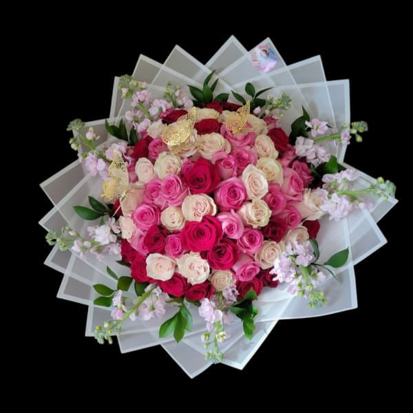 Large bouquet of pink and cream roses with translucent wrapping