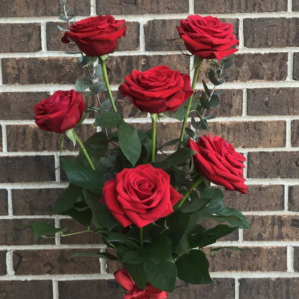Bouquet of red roses in a glass vase with a red ribbon