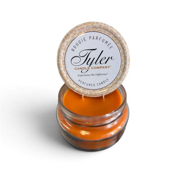 Orange scented candle in a glass jar with a printed lid
