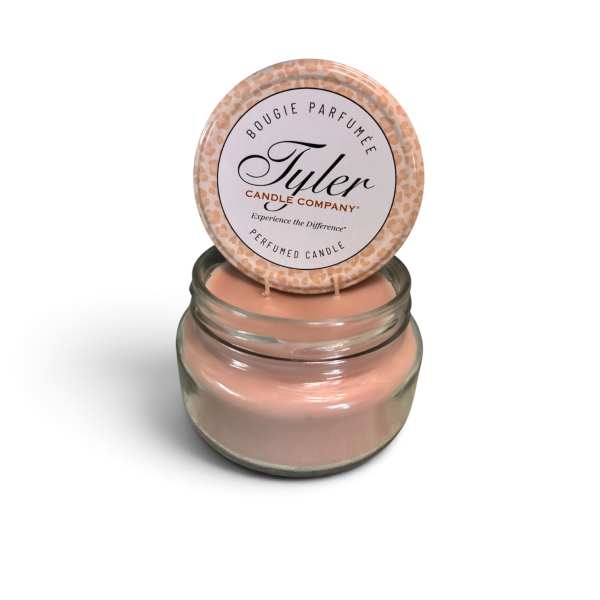 Pink scented candle in a glass jar with a labeled lid