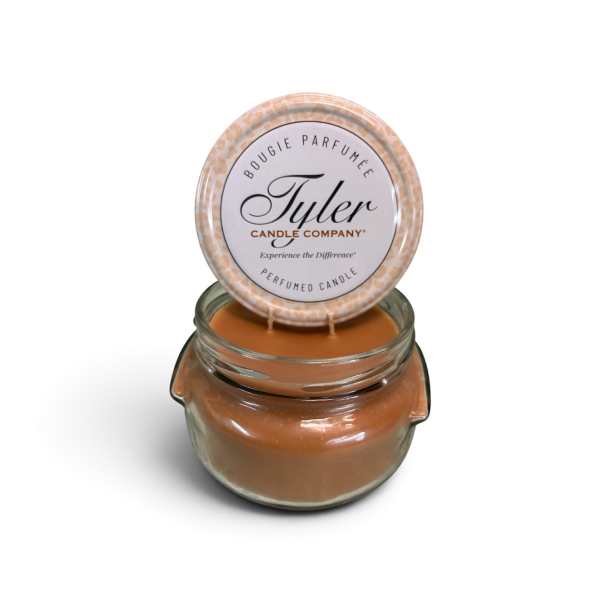 A scented candle in a glass jar with a round lid label