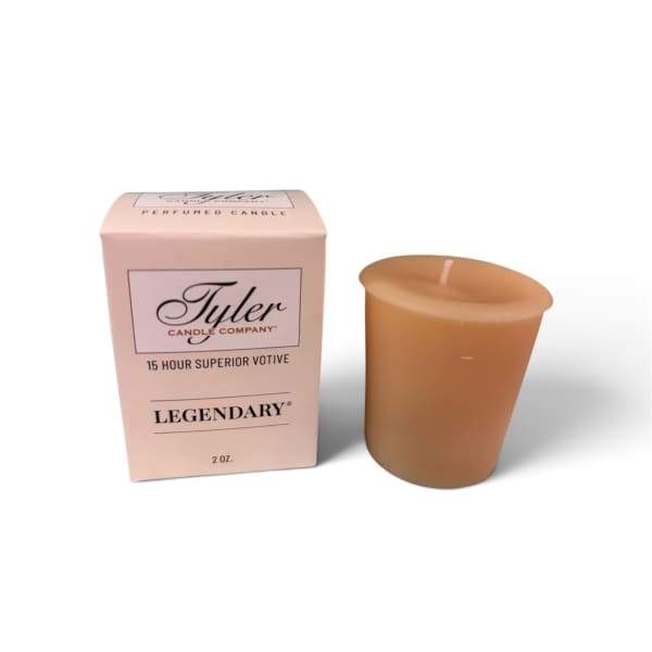 Pink boxed votive candle beside a tan candle cup