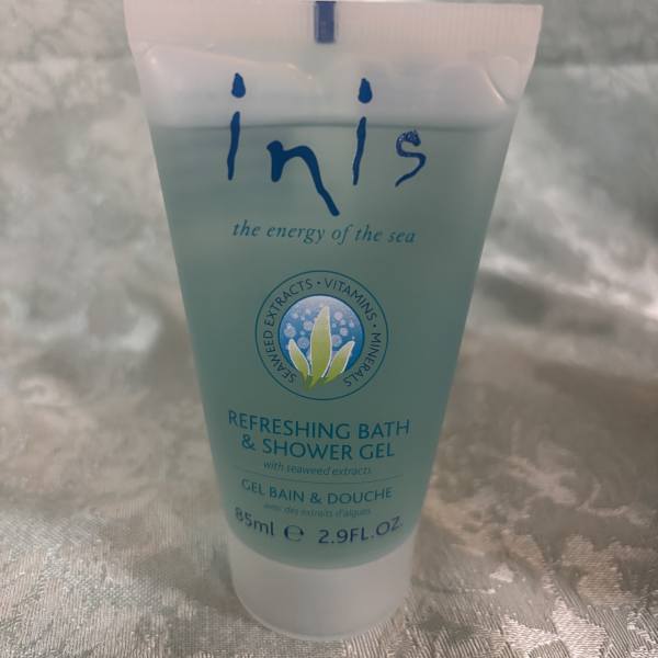 Tube of Inis refreshing bath and shower gel on a fabric surface