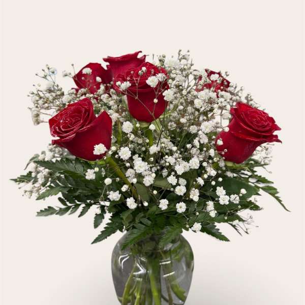 Red roses and baby's breath in a clear glass vase