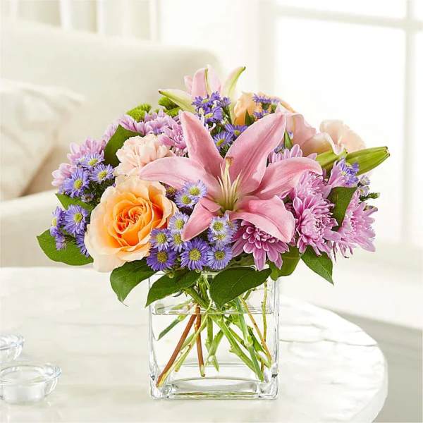 Pink lily and rose bouquet in a clear glass vase