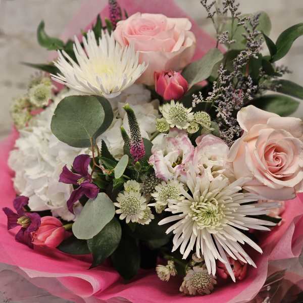 Bouquet of pink and white flowers wrapped in bright pink paper
