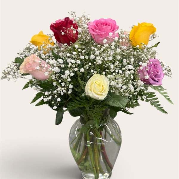 Mixed roses in a clear glass vase with baby's breath