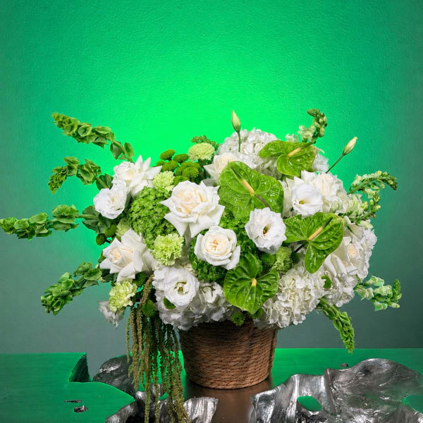 White and green floral arrangement in a woven basket