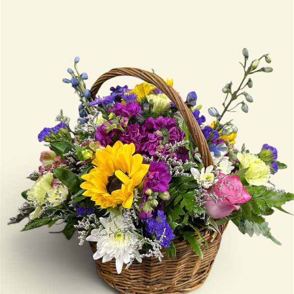 Mixed flower basket with a sunflower, roses, and daisies