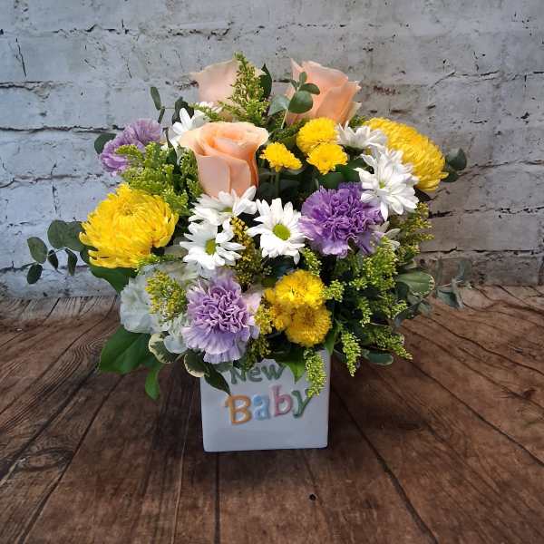 Mixed bouquet in a white cube vase with a "New Baby" decoration