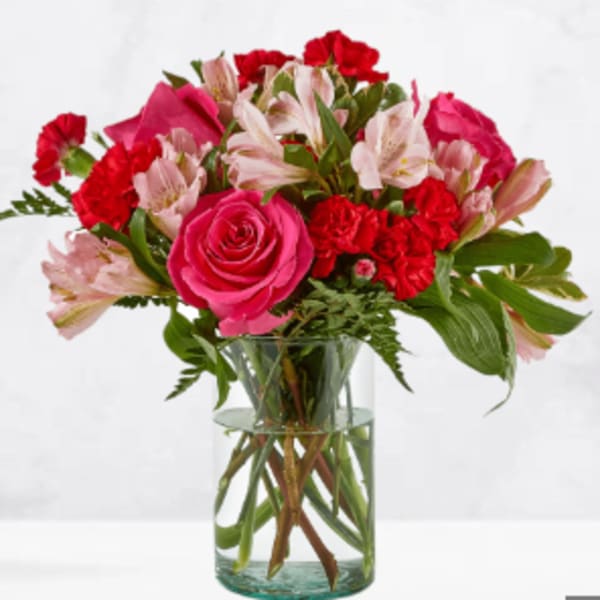 Pink and red mixed bouquet in a clear glass vase