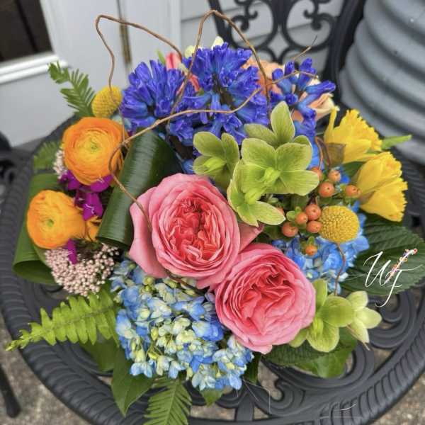 Colorful bouquet with pink roses, blue hydrangeas, and yellow blooms