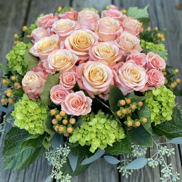 Bouquet of pale pink and peach roses with green hydrangeas