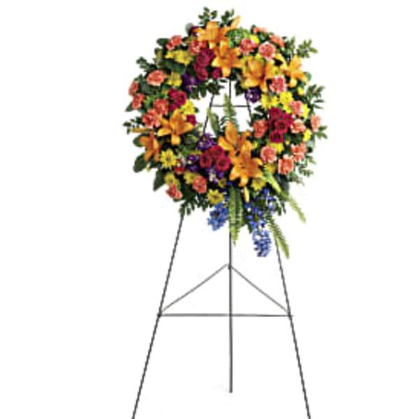 Colorful standing wreath of mixed flowers on a tall metal easel