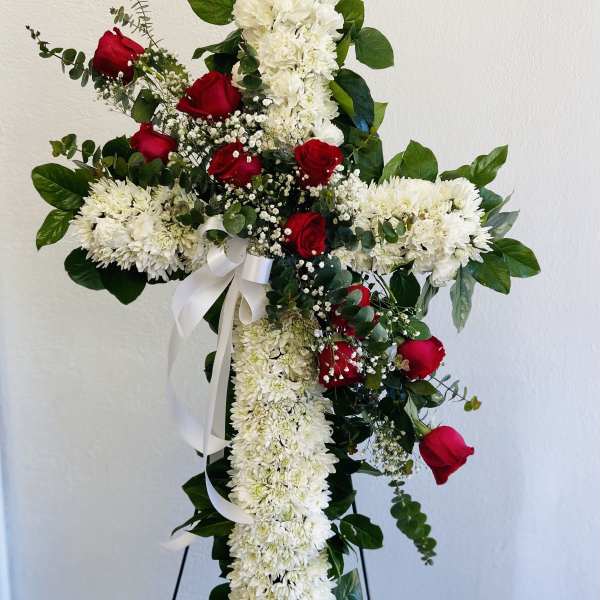 Cross-shaped floral tribute with red roses and white chrysanthemums
